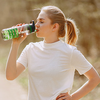 woman drinking water from water bottle