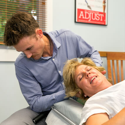 Dr. Mitchell adjusting woman's neck on table