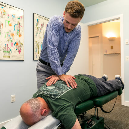 Dr. Mitchell doing back adjustment on man