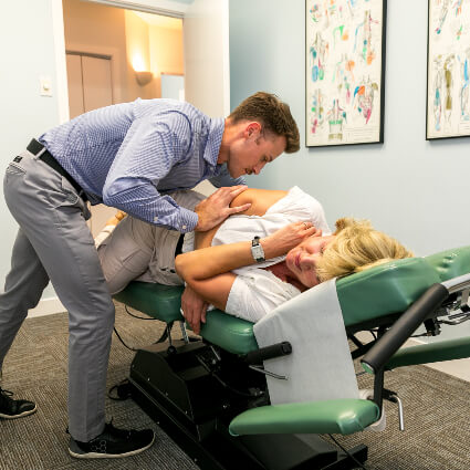 Woman getting adjustment from Dr. Mitchell