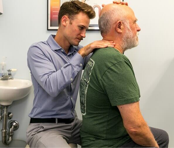 Harvard Chiropractor Dr. Mitchell adjusting senior man