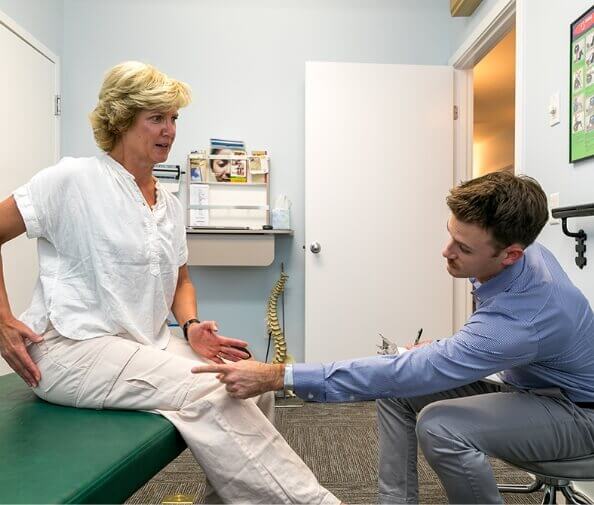 Dr. Mitchell talking to patient on adjusting table