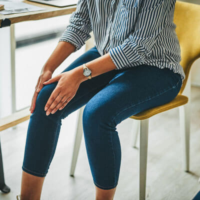 person sitting in a chair with leg pain