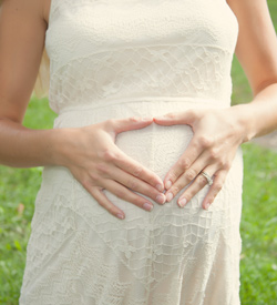 pregnant woman with hands on belly Healthy Beginnings with prenatal chiropractic care at One Love Chiropractic in Asheville