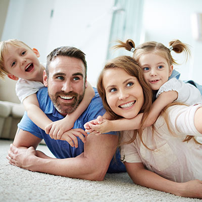 smiling family sitting on carpet