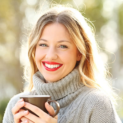 Happy woman with coffee on winter