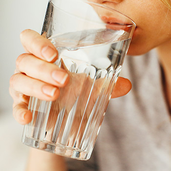 woman drinking water from a glass