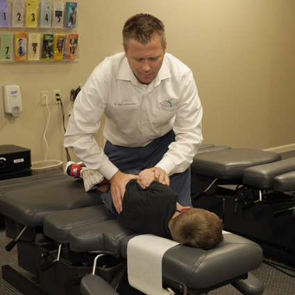 Dr. Alexander adjusting a child.