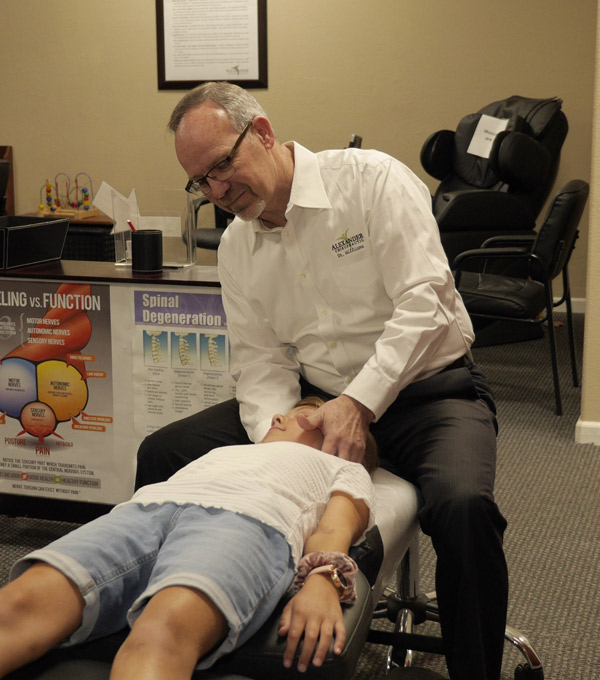 Dr. Daniel adjusting a child's neck.
