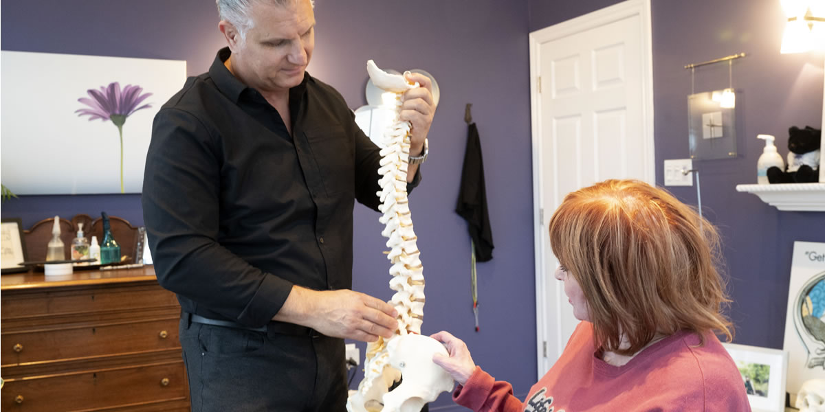 Dr. Varga showing a 3d model of a spine to a patient.