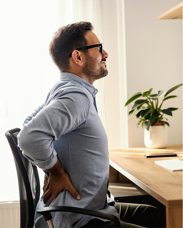 bman sitting at a desk with back pain