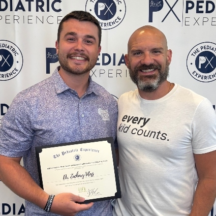 Dr Zack with award and other person