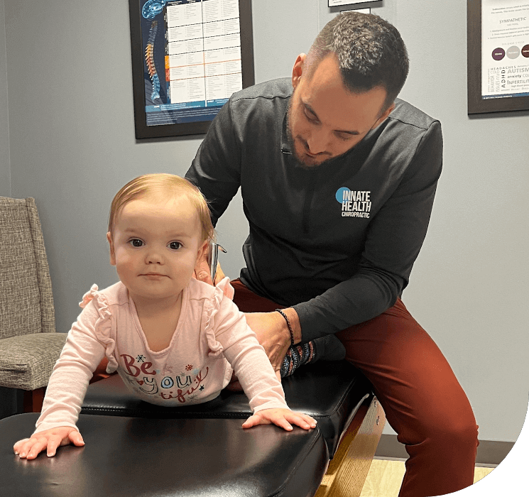 Perrysburg Chiropractor Dr. Nick using activator on baby