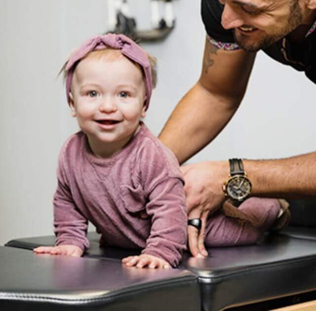 toddler smiling while being adjusted