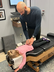 doctor adjusting girl on table