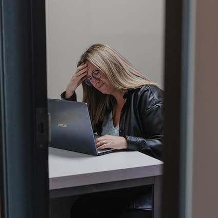 woman working at a laptop with a headache