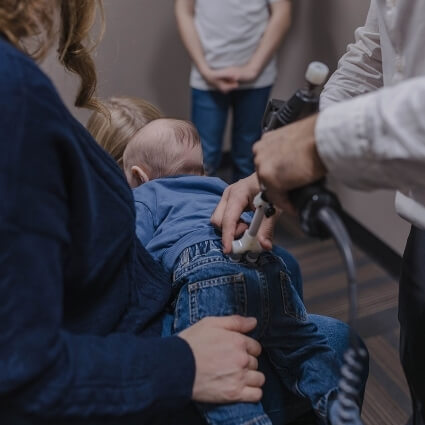 Dr Logan adjusting kids back with a tool