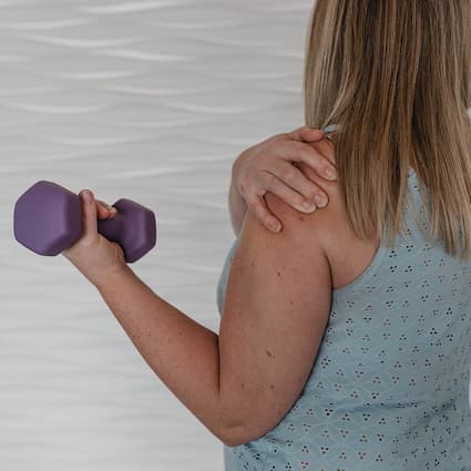 man holding his shoulder in pain