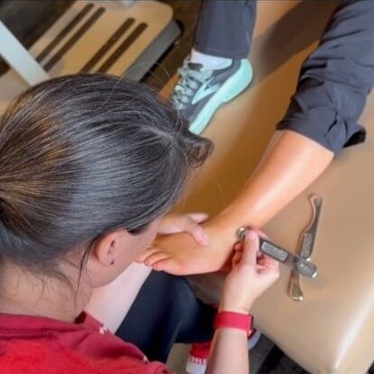 Advanced Chiropractic chiropractor using tool on persons ankle