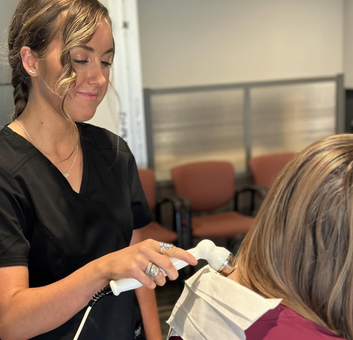 Advanced Chiropractic team member using tool on persons neck