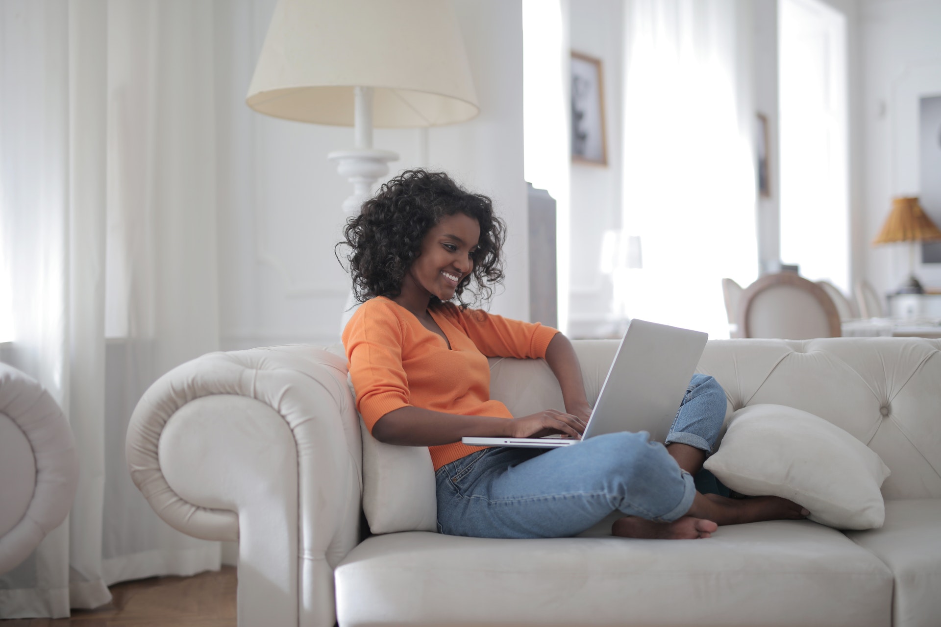 woman-sitting-on-white-couch-using-laptop-computer-3960127