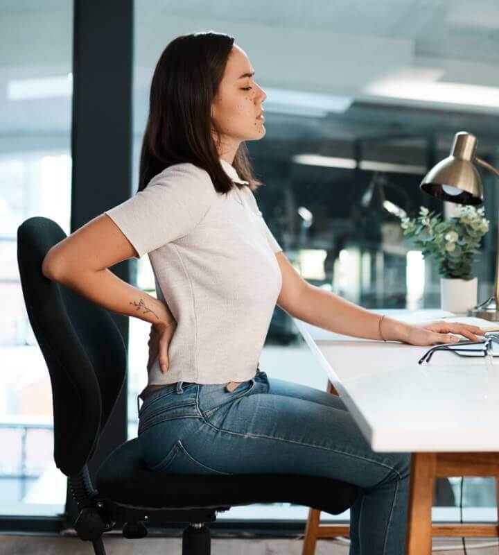 Female sitting on chair with lower back pain