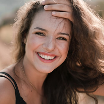 beautiful woman smile widely holding her forehead