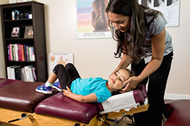 Pediatric Chiropractor South Granville Chiropractor, Dr. Rozeela Nand adjusting a child.