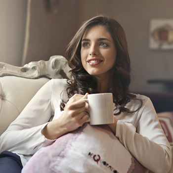 woman sitting on sofa with coffee mug