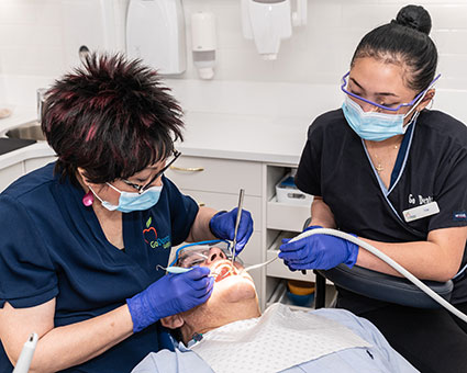 Dentist and hygenist cleaning teeth