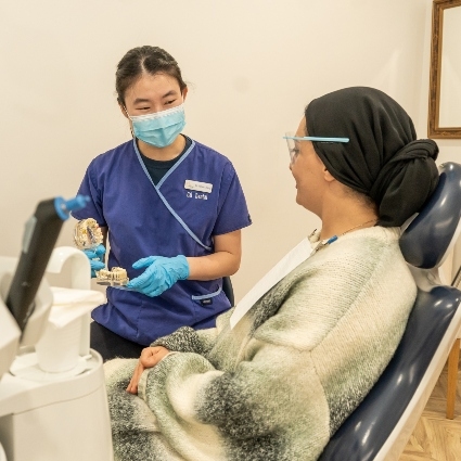 Maddington chiropractor Dr Jamie showing patient a teeth model
