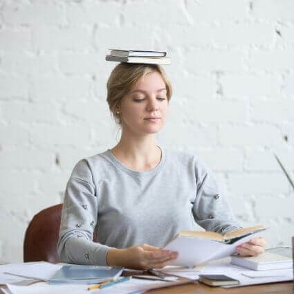 woman-at-desk-balancing-books-on-head-for-perfect-posture-sq