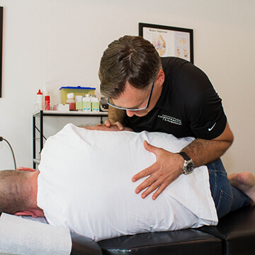 Dr. Michael Mekis adjusting patient's back