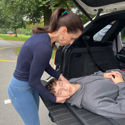 Dr. Celina adjusting someone's neck in an SUV