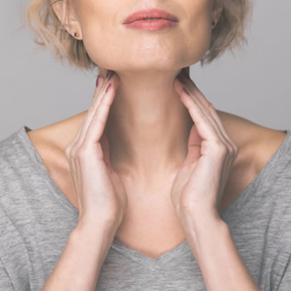woman hands on thyroid