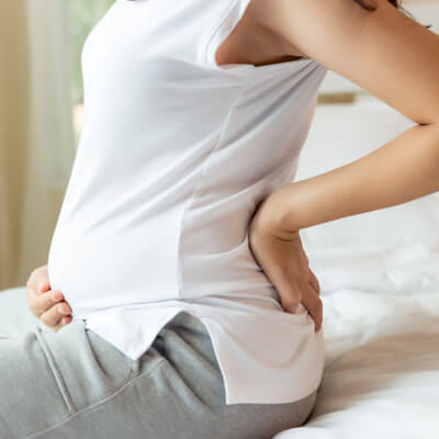 Pregnant woman on edge of bed