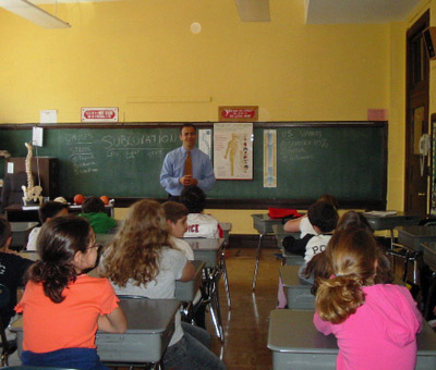 Dr. Shire stands in front of classroom