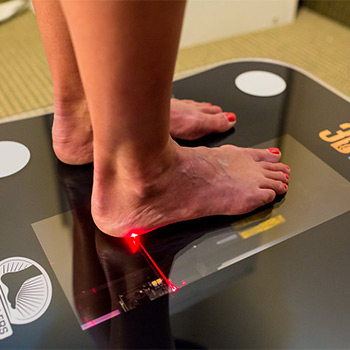 woman getting her feet scanned for custom orthotics