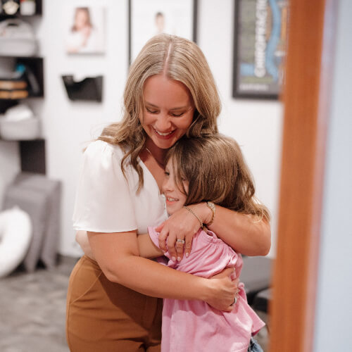 Chiropractor hugging a young child