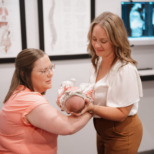 Patient and chiropractor holding a baby