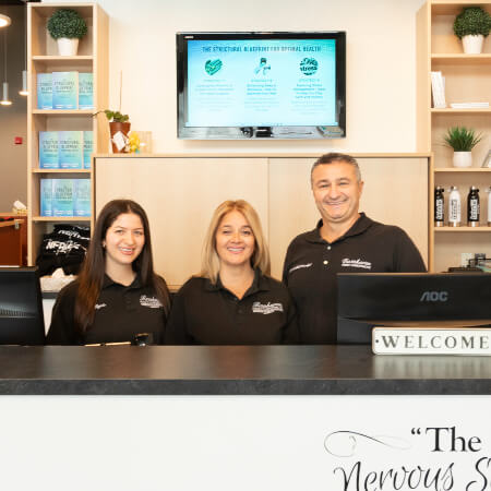Barrhaven Family Chiropractic team standing behind the reception desk