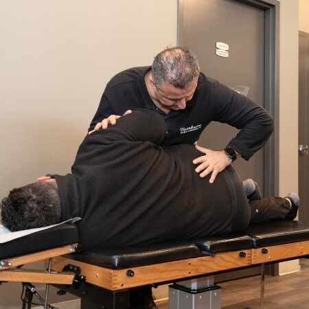 Chiropractor adjusting patient's lower-back