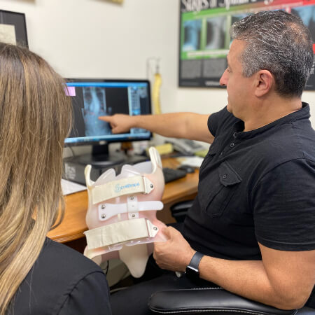 Chiropractor discussing Advanced ScoliBrace 3D spinal bracing system with patient