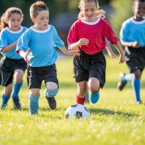 children chasing soccer ball