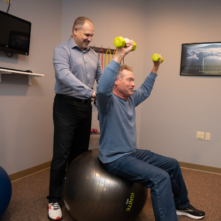 Chippewa Falls chiropractor assisting patient with exersice rehabilitation