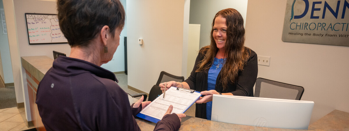 Receptionist handing over paperwork to patient