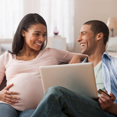pregnant couple looking at computer