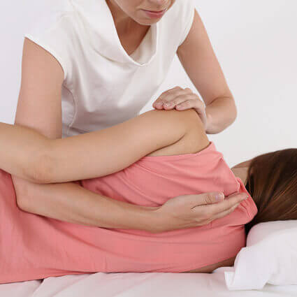 woman-pink-shirt-laying-on-table-having-mid-back-adjusted-sq