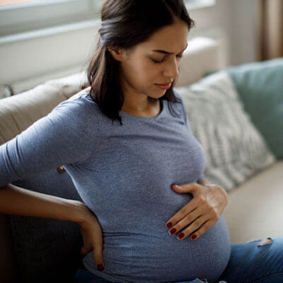 Pregnant woman holding back in pain