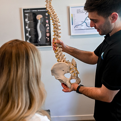 talking with patient and showing them a spine model